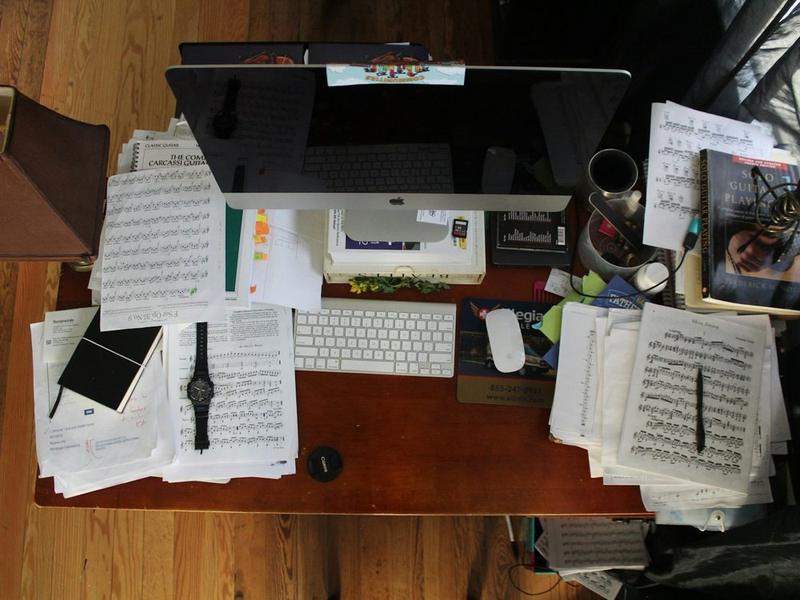 Un bureau vu d'en haut, couvert de papiers empilés.